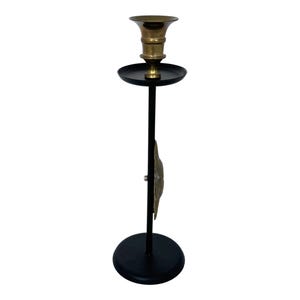 Peut inclure: Un chandelier noir et haut avec un bougeoir en laiton. Le chandelier a une base ronde et un &eacute;l&eacute;ment d&eacute;coratif en laiton. Le bougeoir est con&ccedil;u pour contenir une seule bougie. Le design g&eacute;n&eacute;ral est simple et &eacute;l&eacute;gant.