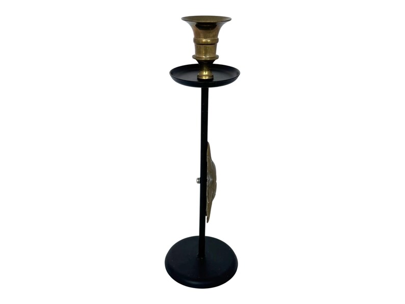 Peut inclure: Un chandelier noir et haut avec un bougeoir en laiton. Le chandelier a une base ronde et un &eacute;l&eacute;ment d&eacute;coratif en laiton. Le bougeoir est con&ccedil;u pour contenir une seule bougie. Le design g&eacute;n&eacute;ral est simple et &eacute;l&eacute;gant.