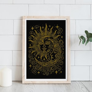 Può includere: Una stampa artistica incorniciata con un design celeste di un sole e una luna con volti, in oro su sfondo nero. L'opera d'arte include stelle e motivi a spirale. La cornice è in legno chiaro e la stampa è esposta su un muro di mattoni bianchi.