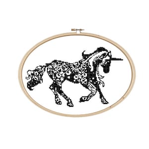 Könnte beinhalten: Schwarzer und weißer Stickrahmen mit einer detaillierten Silhouette eines Einhorns mit einem Blumenmuster.
