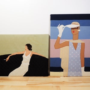 Puede incluir: Dos pinturas enmarcadas de mujeres con ropa vintage. La pintura de la izquierda muestra a una mujer con un vestido blanco sentada en un sofá negro. La pintura de la derecha muestra a una mujer con un vestido azul y blanco con un sombrero blanco.