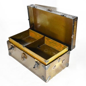 May include: An antique wooden trunk with a brass latch and metal accents. The trunk is open and has a wooden interior with a divider.