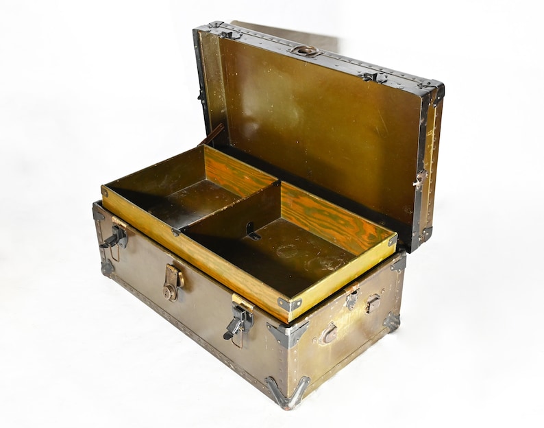 May include: An antique wooden trunk with a brass latch and metal accents. The trunk is open and has a wooden interior with a divider.