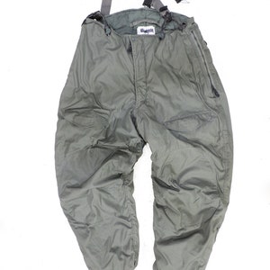 May include: Green insulated bib overalls with suspenders and zippered pockets. The overalls have a label that says "Genuine"