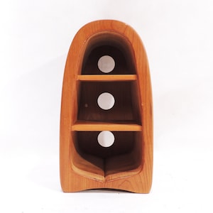 Pu&ograve; includere: Un'unit&agrave; a scaffale in legno con un design curvo unico. Ha tre ripiani e tre tagli circolari. Lo scaffale &egrave; realizzato in legno marrone chiaro.