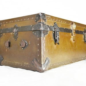 May include: A vintage metal trunk with a green patina finish and black metal hardware. The trunk has a hinged lid with two clasps and a lock. The trunk is decorated with rivets and has a worn, distressed look.