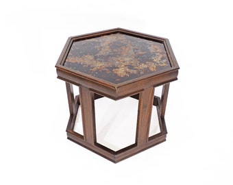 May include: A hexagonal wooden table with a dark brown finish and a glass top with a gold and brown marbled pattern.
