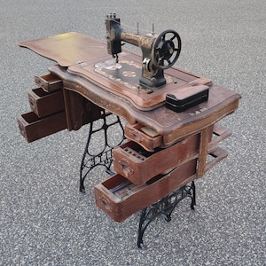 Antique White Rotary treadle sewing machine housed in an original wood cabinet Rustic table