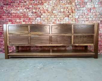 May include: A large, dark brown wooden vanity with eight drawers and a lower shelf. The vanity is made of solid wood and has a rustic, farmhouse style.