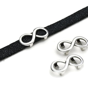 May include: Three silver infinity symbol charms for jewelry making. The charms are designed to be used on leather or other types of cord.