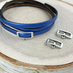 May include: A blue leather bracelet with a silver buckle and two extra silver buckles.