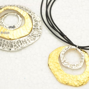 May include: A gold and silver necklace with a layered circle pendant. The pendant has three circles, labeled "large", "medium", and "small".