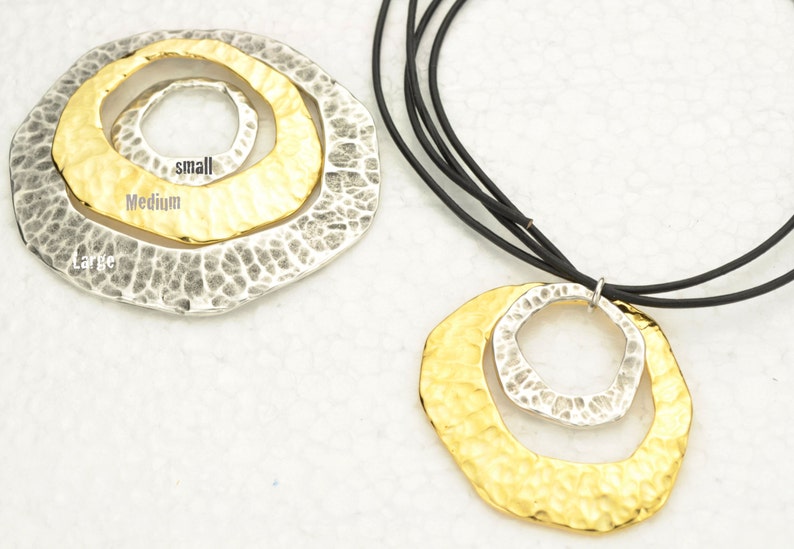 May include: A gold and silver necklace with a layered circle pendant. The pendant has three circles, labeled "large", "medium", and "small".