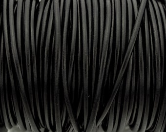 May include: A close-up of a spool of black leather cord. The cord is tightly wound and has a smooth, polished finish.