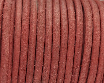 May include: Close-up of a reel of red leather cord. The cord is smooth and has a slightly textured surface.