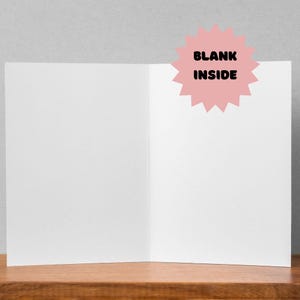 K&ouml;nnte beinhalten: Eine leere Gru&szlig;karte mit einem rosa Sternensticker, auf dem "BLANK INSIDE" steht.