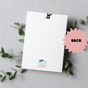 May include: A blank white card with a small black ninja figure at the top. The card has a colourful logo at the bottom with the text "mini flora" and a website address. The back of the card is pink with the word "BACK" in black.