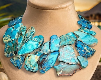 May include: A statement necklace featuring multiple irregular, flat, polished turquoise-colored stone slabs with dark veining, arranged in a layered cluster on a beige display bust. The text VDJ Vivid Designs Jewelry MAKE A STATEMENT is visible.