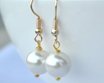 May include: A pair of gold dangle earrings with white pearl drops.