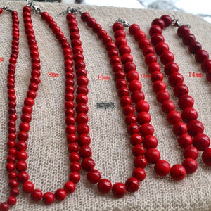 K&ouml;nnte beinhalten: F&uuml;nf Str&auml;nge roter Edelsteinperlen, jede mit einer anderen Gr&ouml;&szlig;e: 6 mm, 8 mm, 10 mm, 12 mm und 14 mm. Die Perlen sind rund und haben eine glatte, polierte Oberfl&auml;che.