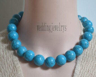 May include: A turquoise blue necklace made of large, oval-shaped beads. The necklace is on a mannequin's neck.