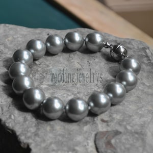 May include: A silver pearl necklace with a magnetic clasp. The pearls are large and round, and the necklace is approximately 18 inches in length.