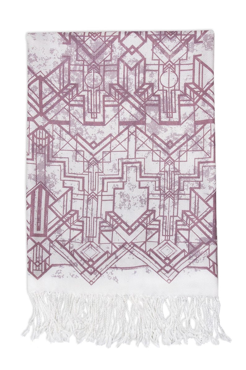May include: A rectangular white scarf with a geometric Art Deco design in shades of mauve and gray. The scarf has a distressed, textured appearance and is finished with a white fringe along the bottom edge.
