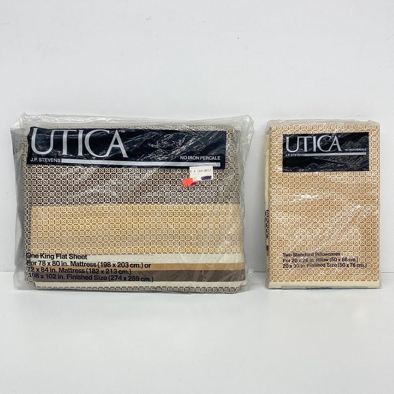 May include: Two sealed packages of Utica brand bed linens. One package contains a king flat sheet, and the other contains two standard pillowcases. The packaging features the brand name and product information. The sheets have a geometric pattern.