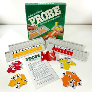 May include: A vintage Parker Brothers "PROBE" word pursuit game. The green box displays the game's title. The game includes letter tiles, word holders, and instruction sheets. The word "RETROSPECT" is spelled out on one of the word holders.