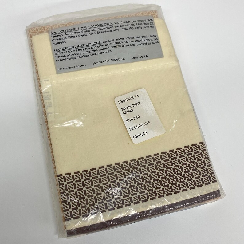 May include: A packaged set of neutral-colored bed sheets. The sheets are cream-colored with a brown geometric border design. The packaging includes text about the fabric composition, care instructions, and product information.