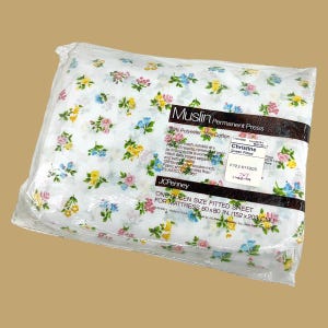 May include: A white ceramic mug with a black handle and the text "But First, Coffee" in a bold, black font. The mug is set against a blurred background, suggesting a cozy setting. The mug appears to be approximately 4 inches tall.