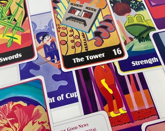 May include: A collection of colorful tarot cards with various illustrations. The cards feature images of swords, a tower, a frog, and other symbolic figures. The text "The Tower 16" is visible on one card. The cards are arranged on a white surface.