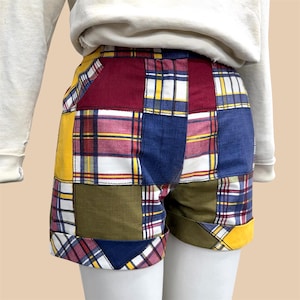May include: Patchwork shorts in a variety of colors including yellow, red, blue, and green. The shorts have a plaid pattern and are made of fabric. The shorts are cuffed at the hem.