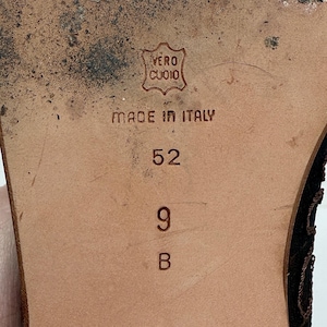 May include: Close-up of a shoe sole. The brown sole features the text "VERO CUOIO" in an emblem, and "MADE IN ITALY". The size is indicated as 9 B and 52.