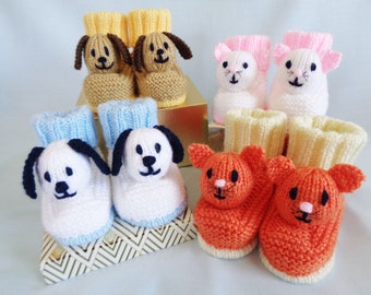 May include: A set of six knitted baby booties with animal faces. Two pairs are brown and white dog booties, one pair is blue and white dog booties, and one pair is pink and white cat booties.