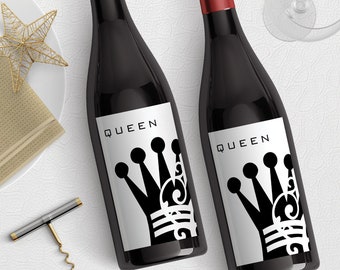 May include: Two bottles of red wine with black and white labels. The labels feature the word "QUEEN" and a stylized crown design.