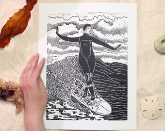 Cross-Step - handmade lino-cut print depicting a winter surfing woman cross-stepping on her longboard on a wave - surf, beach, ocean