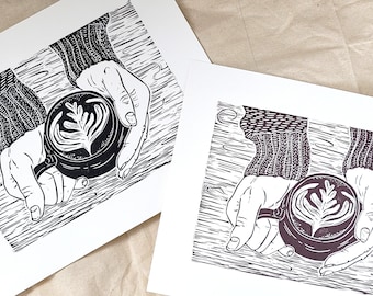 Latte - handmade lino-cut block print depicting hands holding a mug filled with a fancy coffee - cozy, sweater, cafe, brunch, breakfast