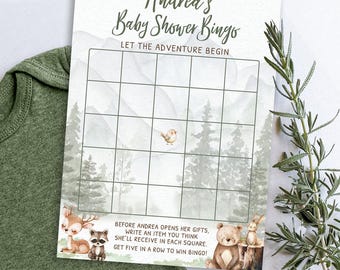 May include: Baby shower bingo card with a woodland theme. The card features a grid for bingo, with illustrations of a deer, raccoon, bear, and bunny. Text includes "Andrea's Baby Shower Bingo" and instructions for the game. The background has a watercolor forest design.