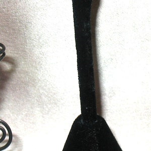 May include: A pair of earrings with a spiral design and a small amber glass bead in the center of each earring.