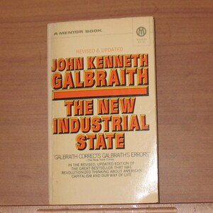 以下が含まれることがあります： ジョン・ケネス・ガルブレイス著「The New Industrial State」のタイトルが書かれた、黄色とオレンジの表紙のメンター・ブックのペーパーバック。本の表紙には、「Revised & Updated」と「Galbraith Corrects Galbraith's Errors - The New York Times」のテキストも含まれています。