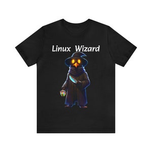 May include: Black t-shirt featuring a white graphic of a wizard holding a knife and a lantern. The text "Linux Wizard" is printed above the wizard.