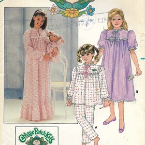 May include: A sewing pattern for making pajamas for children. The pattern includes three different styles: a long-sleeved nightgown with a pink and white polka dot print, a long-sleeved nightgown with a purple print, and a long-sleeved pajama set with a pink, green, and white plaid print. The pattern is for sizes 7-8-10 and is from Cabbage Patch Kids.