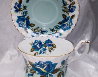 May include: A blue and white teacup and saucer set with a floral design. The teacup has a handle and the saucer has a scalloped edge.