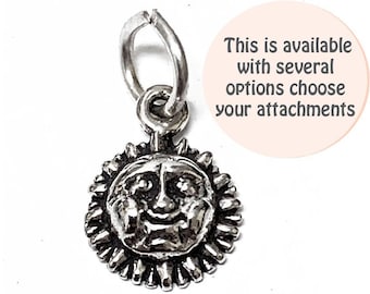 May include: Silver charm featuring a smiling sun face with a textured surface. The charm has a loop for attaching to a necklace or bracelet.
