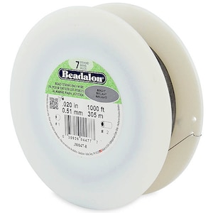 Könnte beinhalten: Eine Spule mit 7-strängigem Beadalon-Perlen-Faden in Silber. Die Spule ist mit der Drahtstärke, 0,020 Zoll oder 0,51 mm, und der Länge, 1000 Fuß oder 305 m, gekennzeichnet.