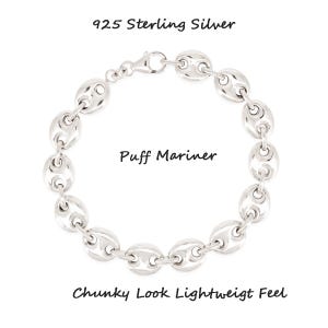 May include: A sterling silver Puff Mariner bracelet with a chunky look and lightweight feel. The bracelet is composed of oval-shaped links. The text "925 Sterling Silver", "Puff Mariner", and "Chunky Look Lightweight Feel" are visible.