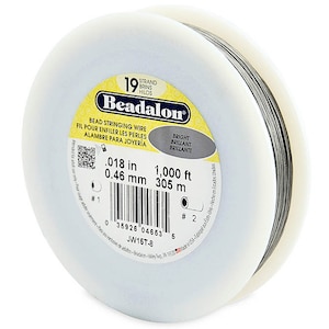 Könnte beinhalten: Eine Spule Beadalon 19-fädiges Perlen-Faden. Der Draht ist 0,46 mm dick und 305 Meter lang. Die Spule ist weiß mit einem gelben Etikett, auf dem "Beadalon" steht und die Produktdetails aufgedruckt sind.