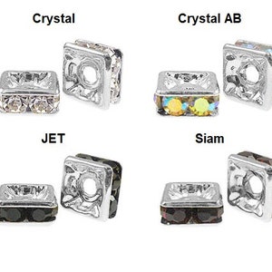 May include: Four square-shaped crystal beads in various colors: Crystal, Crystal AB, JET, and Siam. Each bead has a silver-colored metal frame and a central hole. The Crystal beads are clear, the Crystal AB beads have an iridescent effect, the JET beads are black, and the Siam beads are a deep red.