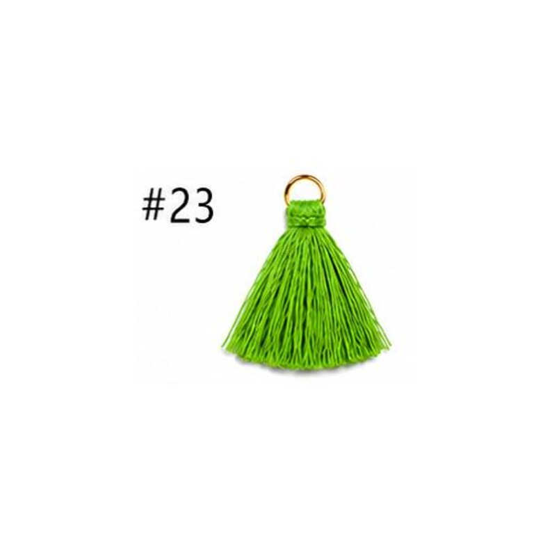 Peut inclure: Un pompon vert lime vif compos&eacute; d'une grappe dense de fils fins suspendus, fix&eacute;s au sommet par un n&oelig;ud tress&eacute; et un petit anneau m&eacute;tallique dor&eacute;. Le num&eacute;ro #23 est imprim&eacute; en noir sur le c&ocirc;t&eacute; gauche du pompon.